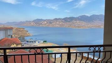 A balcony with a view of a lake and mountains.
