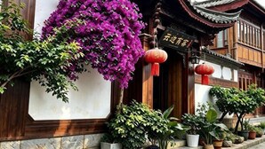 A traditional building with a wooden facade, a hanging purple flower arrangement, and a red lantern. - Yongxia Boutique Inn Lijiang (Lijiang)