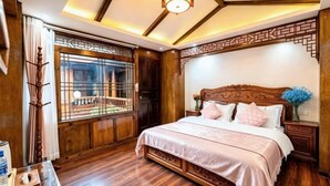 A traditional room with a wooden bed, a window with a view, and a decorative ceiling. - Yongxia Boutique Inn Lijiang (Lijiang)