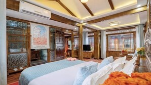 A hotel room with a large bed, wooden furniture, a TV, and a map on the wall. - Yongxia Boutique Inn Lijiang (Lijiang)