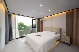 Un dormitorio moderno con una cama grande, una mesita de noche y vistas al exterior.