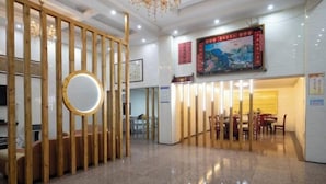 A hotel lobby with a wooden partition, a round mirror, and a dining area with tables and chairs. - Wugong Mountain near Shuiya Residence (Luxi)