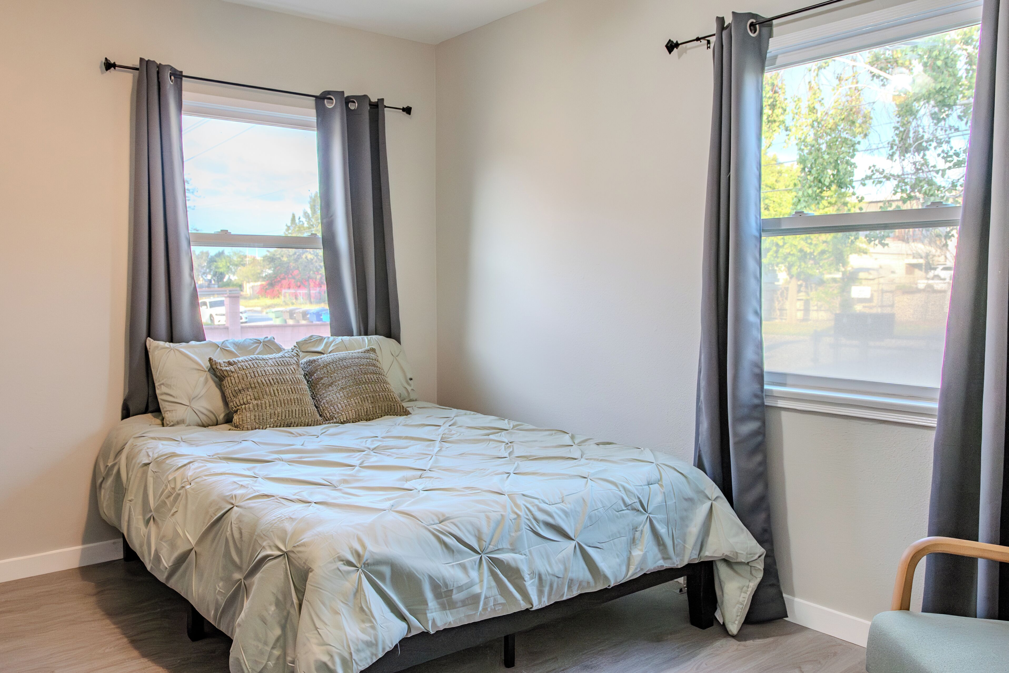A bedroom with a bed, curtains, and a window.