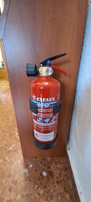 Un extincteur fixé à un mur en bois.