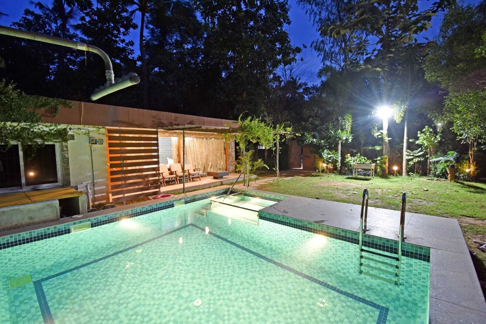 Una piscina con bordo piastrellato, zona relax coperta e spazio esterno ben illuminato, immerso nel verde.