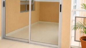 Une pièce dotée d’une porte-fenêtre coulissante, d’une plante en pot et d’une fenêtre.