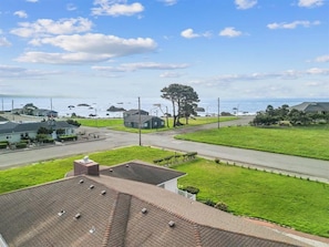 A residential area with houses, a road, and a view of the ocean.