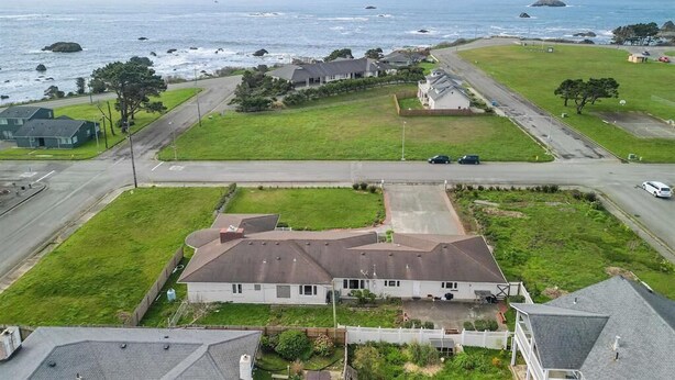 Vista aérea de una zona residencial costera con casas, una carretera y el océano.
