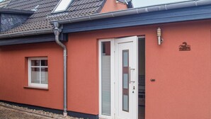 A building with a red exterior, a white door, and a satellite dish on the roof. - Nice home in Neubrandenburg with WiFi (Neubrandenburg)