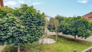 A garden with mature trees and a metal trellis structure. - Nice home in Neubrandenburg with WiFi (Neubrandenburg)