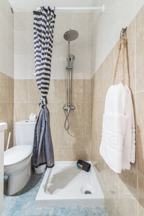 Ein Badezimmer mit Dusche, Toilette und Badewanne.