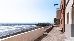 A coastal walkway with a stone wall, benches, and a street lamp. - Home2Book Stunning BeachFront Apt, Pozo Izquierdo (Pozo Izquierdo)