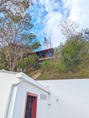 Um edifício com varanda com vista para um jardim.