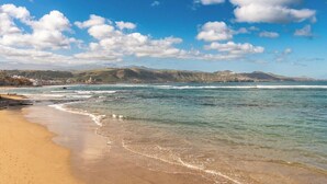 A coastal beach with clear skies and gentle waves.