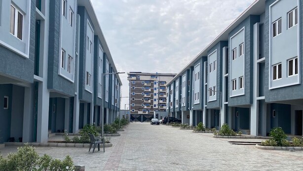 A residential building with a central courtyard, featuring a paved walkway and small plants. - Beach Side Shortlet Apartment Lekki (Lekki)