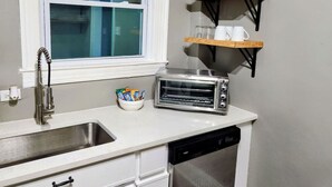 A compact kitchen with a sink, a toaster, and a dish rack. - The White House 2 BR 1 BA (Savannah)