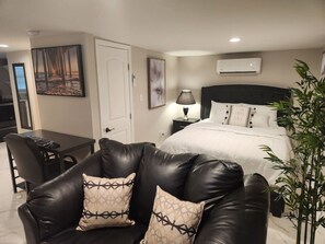 A hotel room with a bed, a desk, a chair, and a plant. - Serenity Retreat Nook (Savannah)
