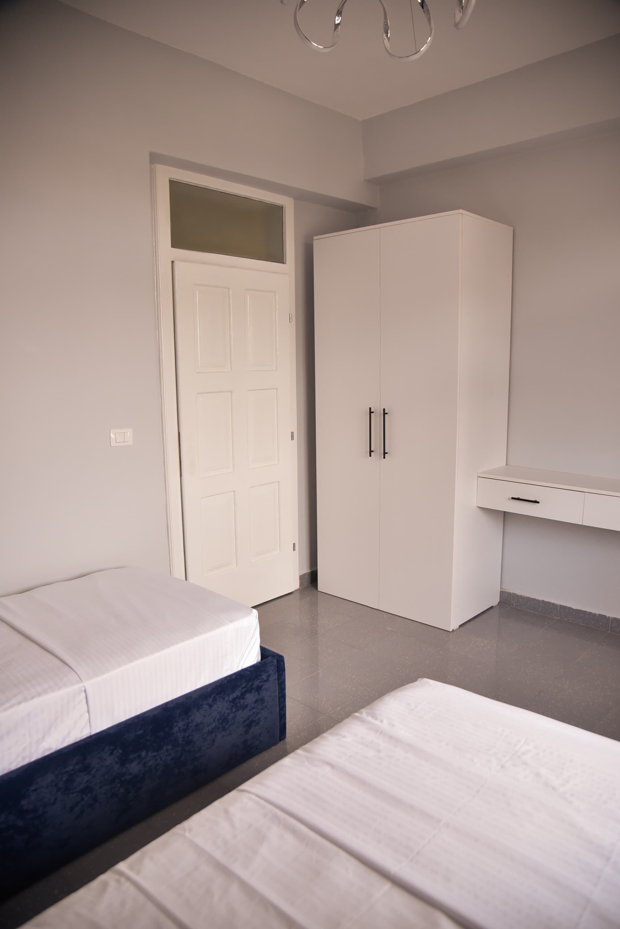 Un dormitorio con cama, armario y escritorio.