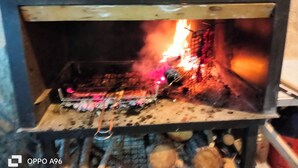 Een houtkachel met hout en een brandend vuur.