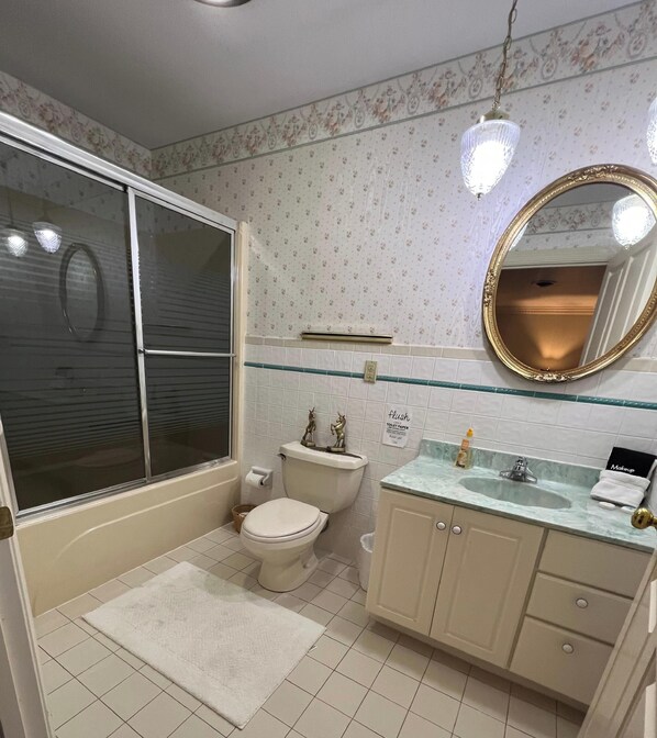 A bathroom with a toilet, sink, vanity, and a shower area. - Kentucky's Majestic Mountaintop Estate with pool: The Bluegrass Palace (Langley)