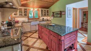 A kitchen with a large island, wooden ceiling, and a view to the living area. - Alpine Chateau Stowe-7 BR-6 bath-Game Room, Firepit, Pool! (Stowe)