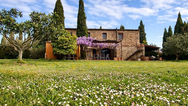 A stone building with a garden in front, surrounded by trees. - Hostal Nou de Crespià (Crespià)