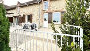 A stone house with a balcony, a white fence, and green foliage. - L'Escale Champenoise (PLESSIS BARBUISE)
