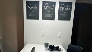 A conference room with a white table, three framed motivational posters, and a black chair. - Harmonious Character & Comfort (Huntsville)
