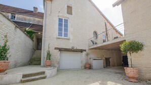 A courtyard with a white garage door, a small staircase, and potted plants.