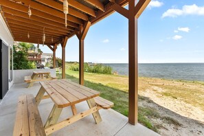 A covered outdoor area with picnic tables and a view of the water.