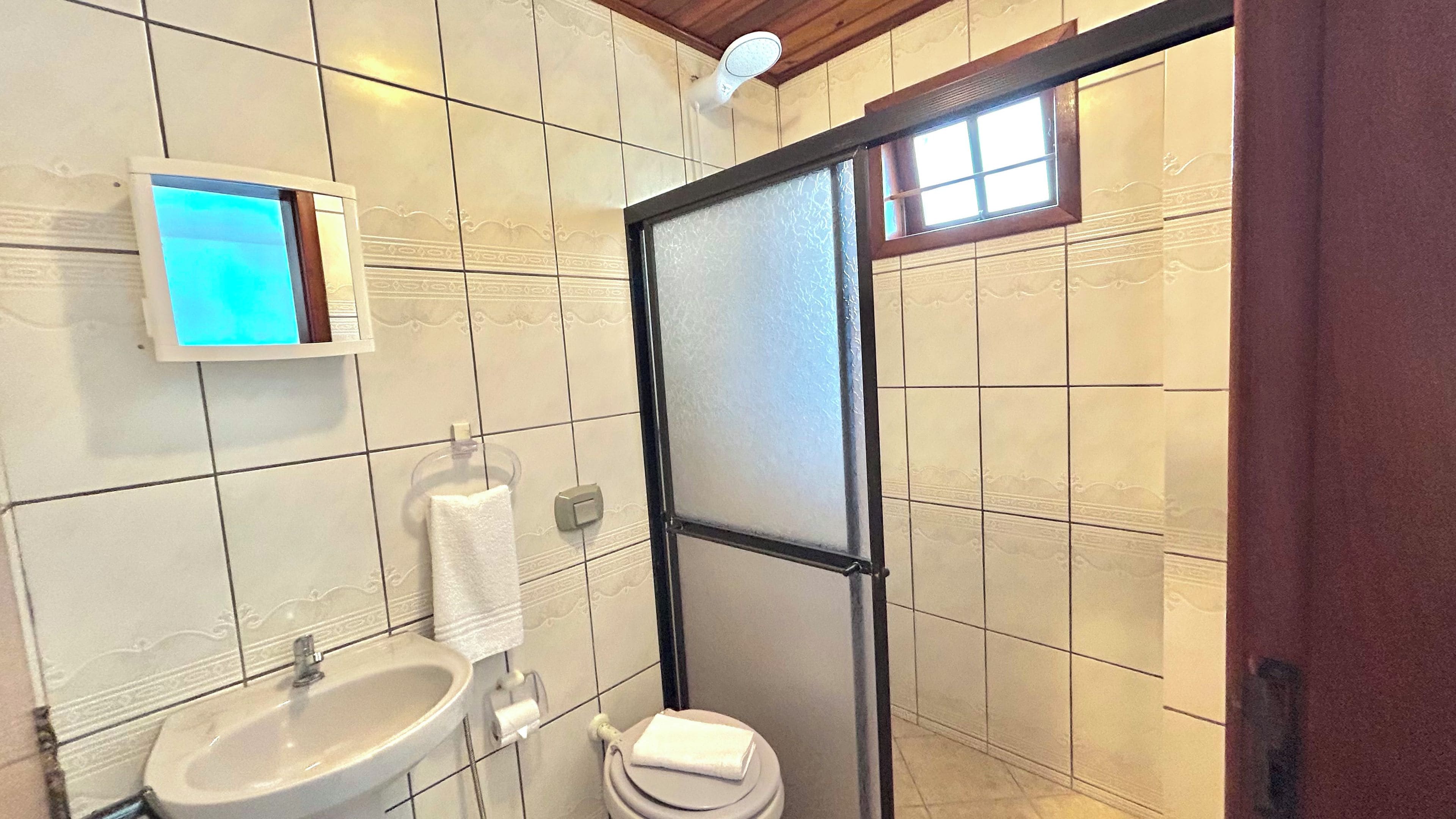 A bathroom with a white sink, toilet, and a towel rack.