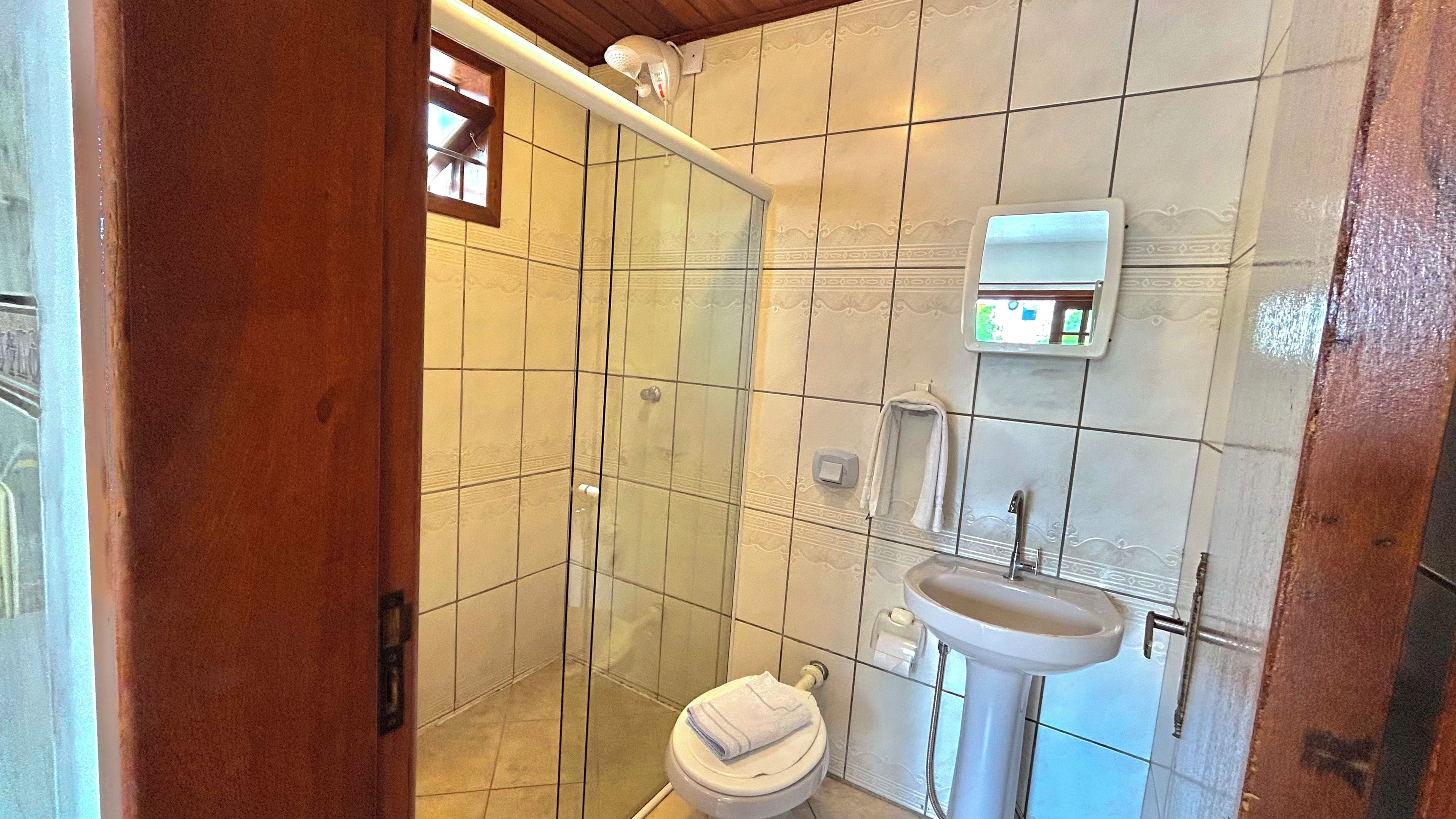 Une salle de bain avec des toilettes, un lavabo et une douche.