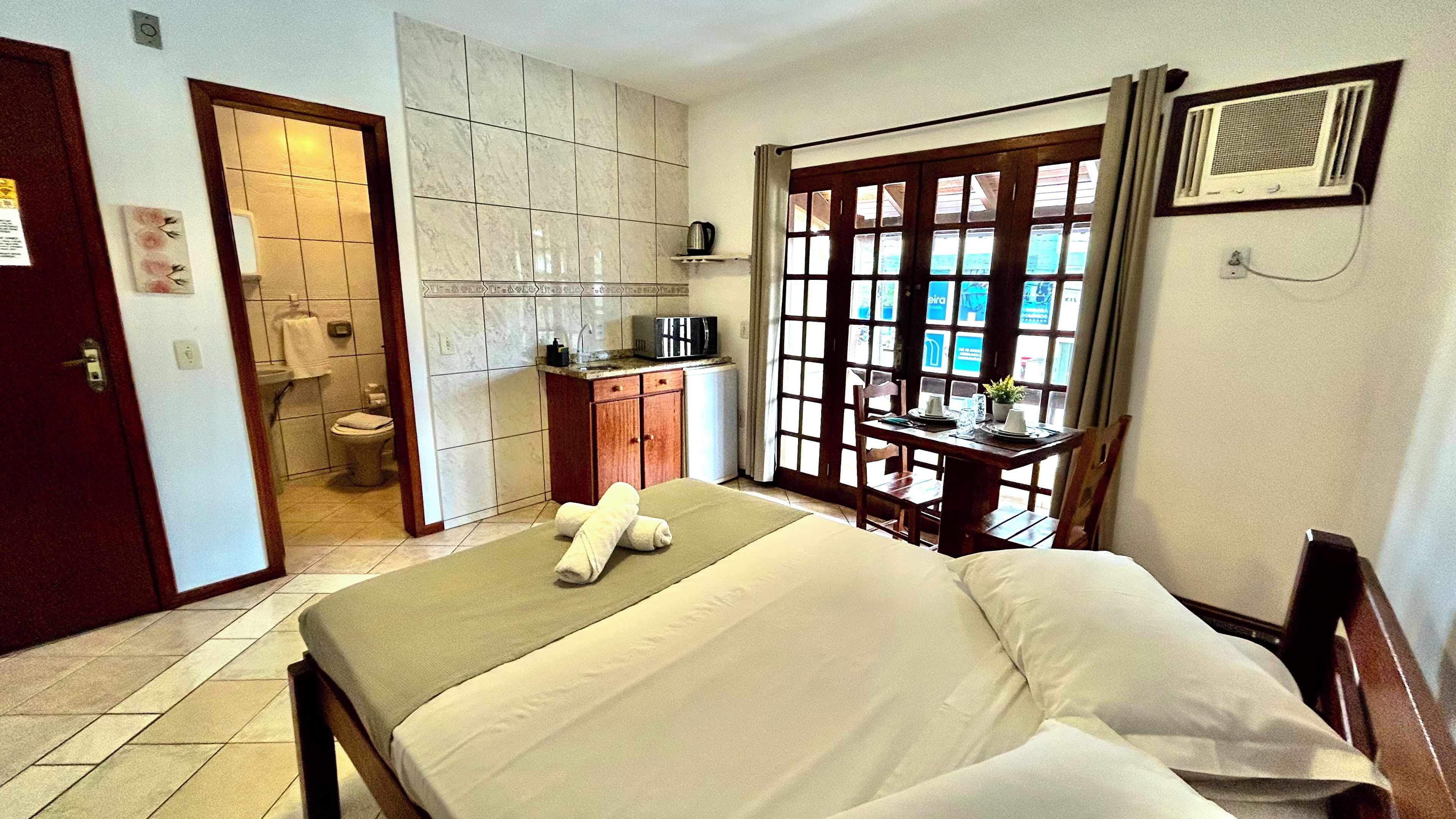 Une chambre d’hôtel avec un lit, un bureau, une vue par la fenêtre et une salle de bain.