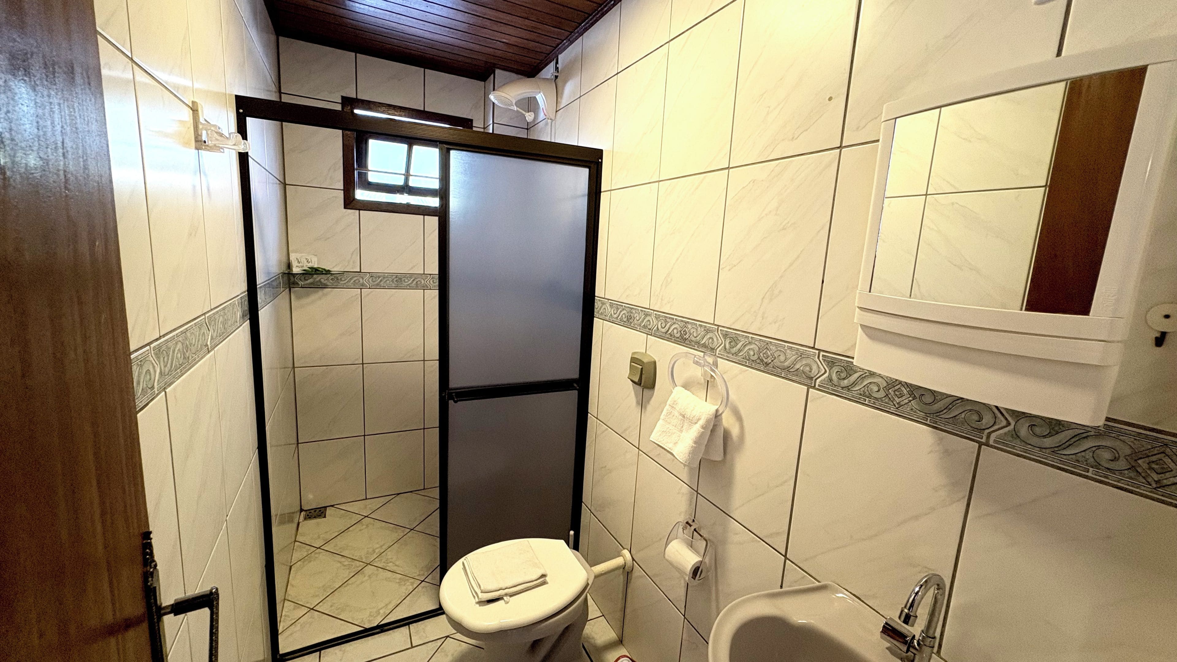 Un baño con inodoro, cabina de ducha y lavabo.
