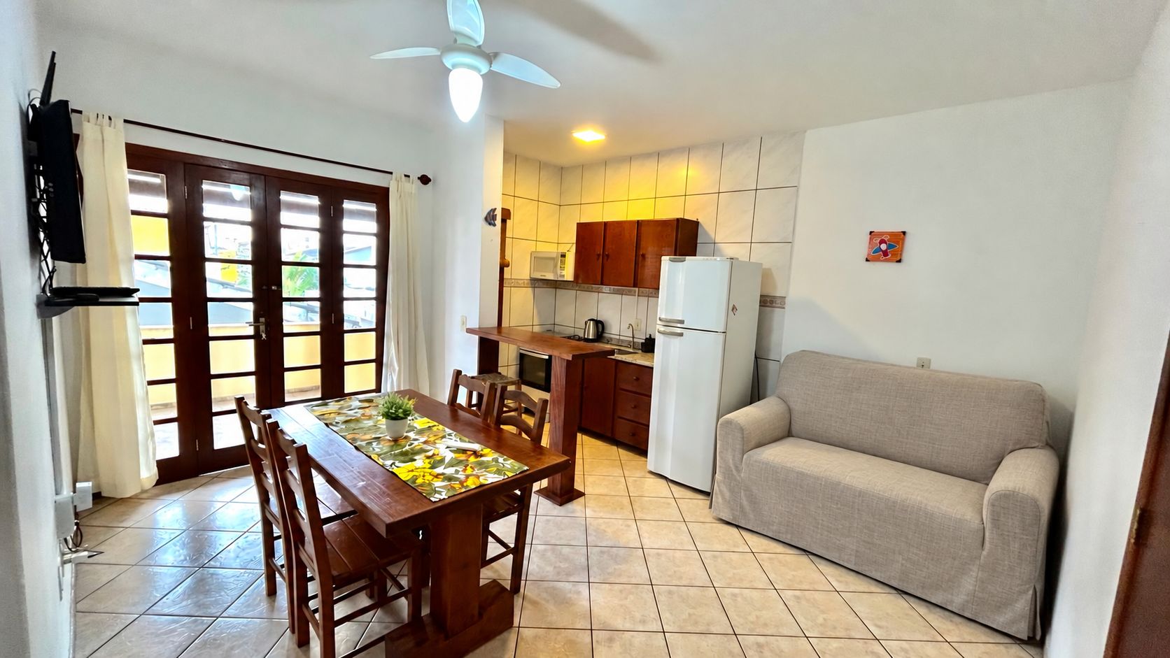 A compact living space with a dining area, kitchenette, and a sofa.