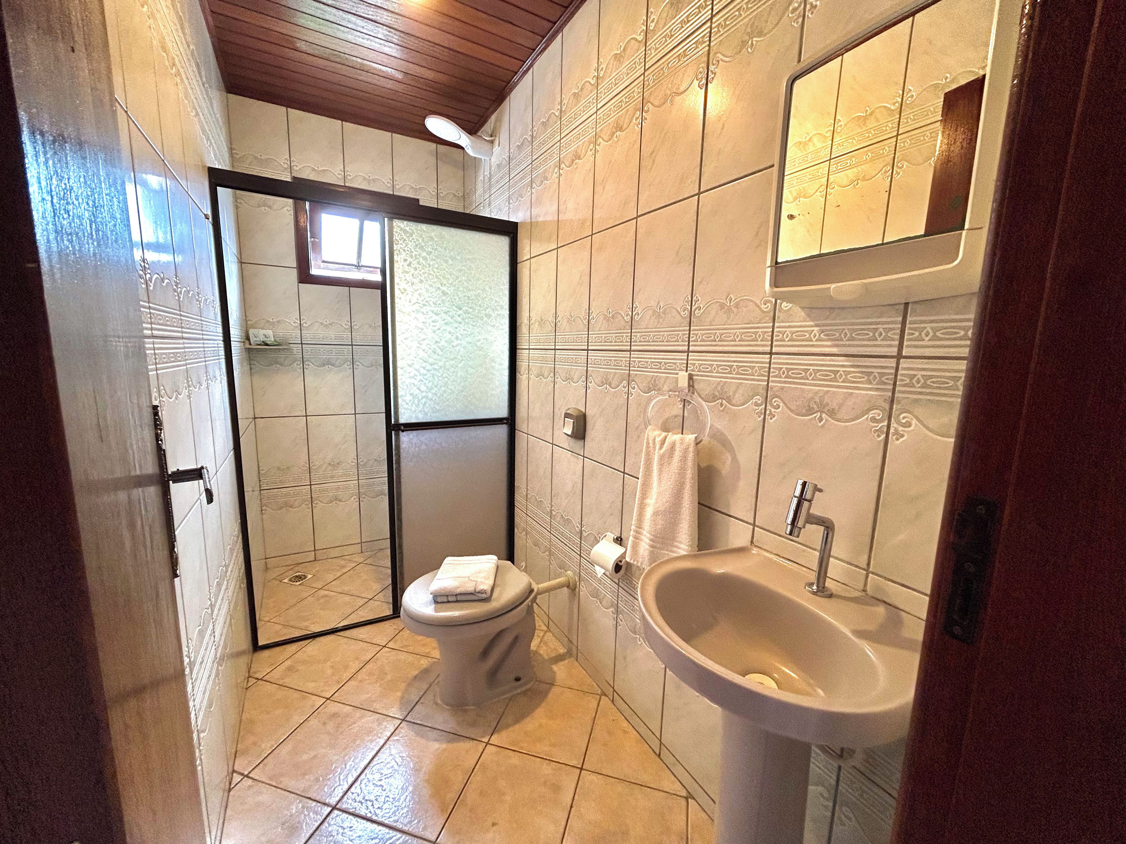 A bathroom with a toilet, sink, and shower area.