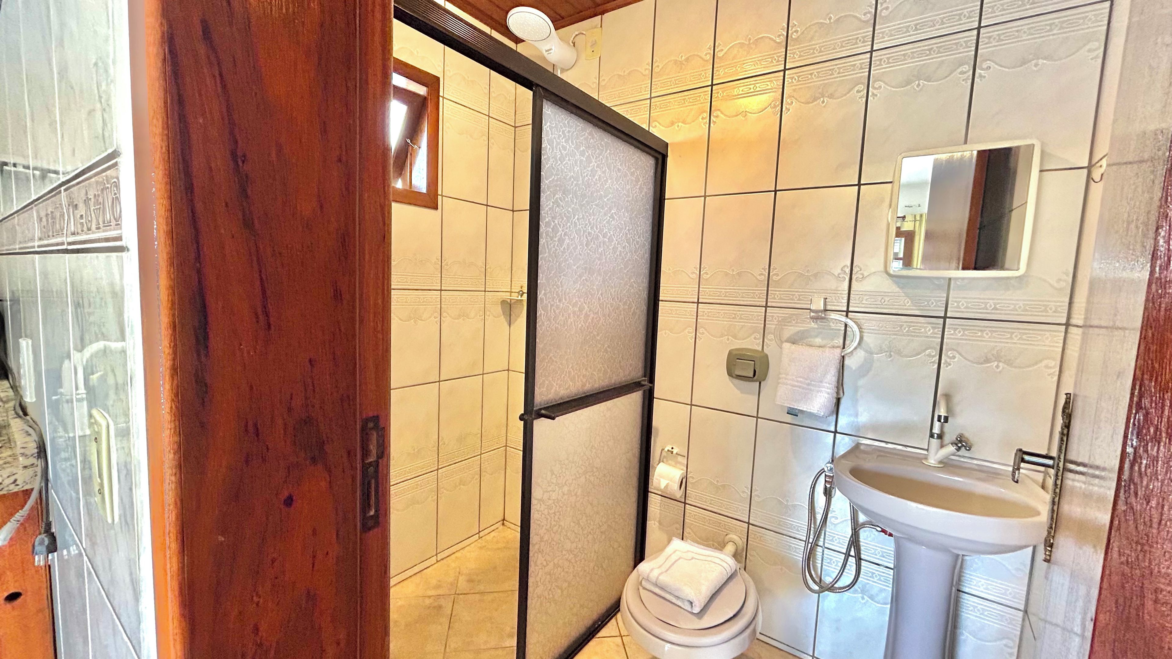 A bathroom with a toilet, sink, and shower area.