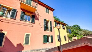 A multi-story building with balconies and shutters, featuring a stone-paved ground. - 1 bedroom pet friendly home in Avegno (Avegno)