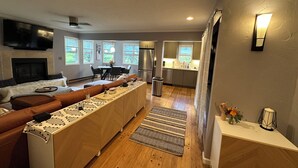 A modern kitchen with a central island, a dining area with a table and chairs, and a living room with a sofa and fireplace. - Fantastic mountain village condo in Steamboat Springs! Minutes to ski area base! (Steamboat Springs)