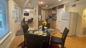 A dining area with a glass table, black chairs, and a vase with yellow flowers. - Charming 2-bedroom 1 bath, Livingroom, full kitchen, WiFi & AC in Alpharetta.  (Alpharetta)
