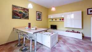 Una cocina moderna con comedor, televisor y un armario blanco.