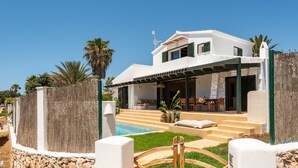 A modern two-story house with a swimming pool, outdoor seating, and a stone wall. - Villa 'Binimadi' with Sea View, Wi-Fi and Air Conditioning (Binisafua)