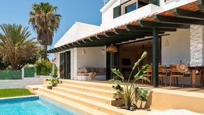 A modern house with a swimming pool, outdoor seating, and a pergola. - Villa 'Binimadi' with Sea View, Wi-Fi and Air Conditioning (Binisafua)