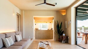 A modern living room with a sofa, a wooden table, and a ceiling fan. - Villa 'Binimadi' with Sea View, Wi-Fi and Air Conditioning (Binisafua)