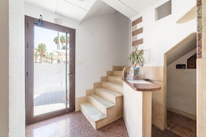 L’entrée d’un hôtel, avec une porte en verre, un escalier et un comptoir d’accueil.