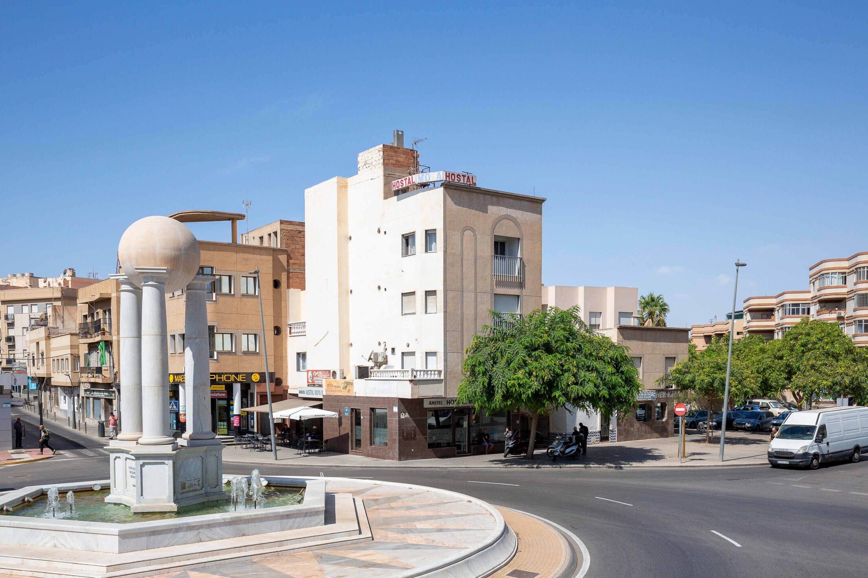 Un hotel con una glorieta, una fuente y un letrero que dice 'HOSTAL'.