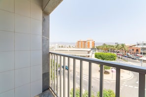 Un balcon offrant une vue sur le paysage urbain, avec des bâtiments et un rond-point.