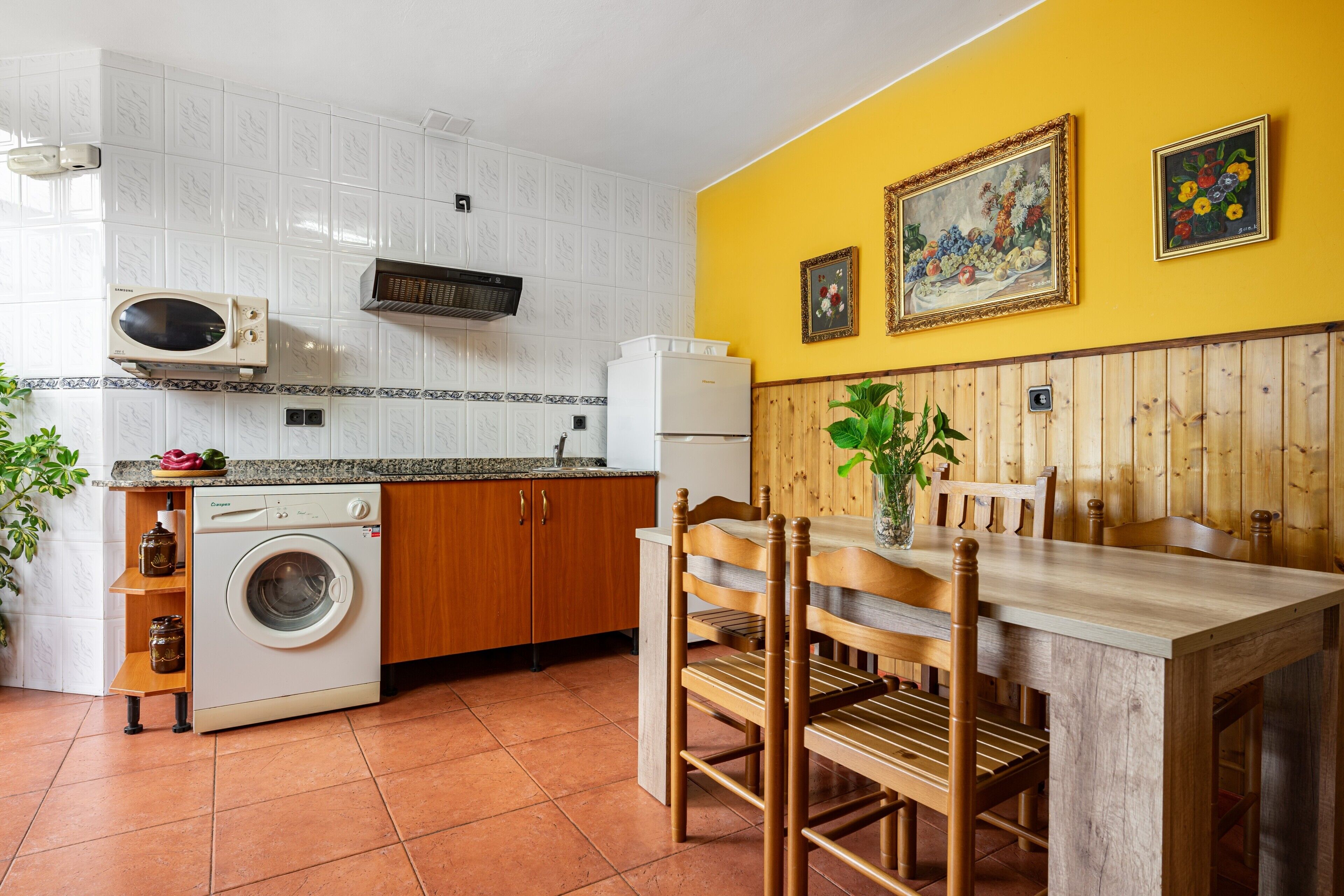 Cocina compacta con lavadora, microondas y refrigerador.