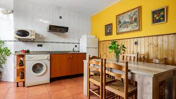 Cocina compacta con lavadora, microondas y refrigerador.