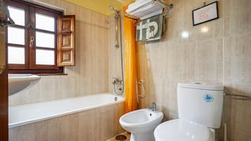A bathroom with a bathtub, a bidet, and a toilet.